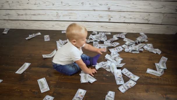 Bambino ragazzo e un sacco di soldi sul pavimento hd — Video Stock