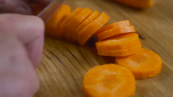 Corta zanahorias en una tabla de cortar — Vídeo de stock