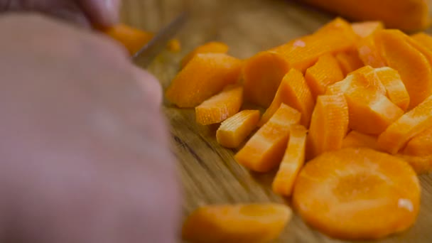 Мелко режет морковь на доске — стоковое видео