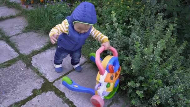 Barn utanför promenader med en leksak — Stockvideo