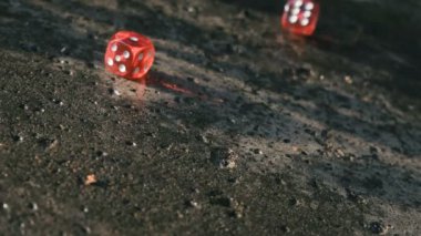 Kırmızı zar yavaş çekimde bir betonarme döşeme üzerinde haddeleme