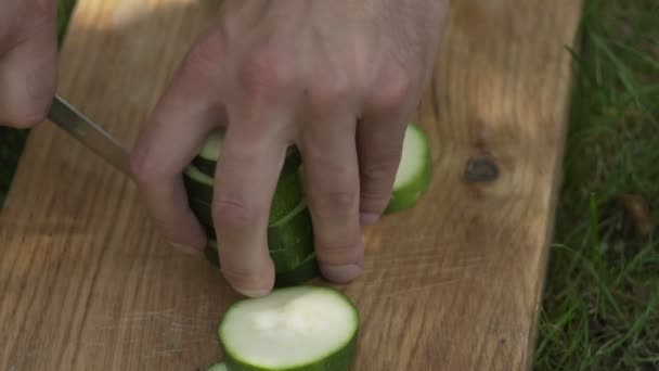 Man skär zucchini noggrant — Stockvideo