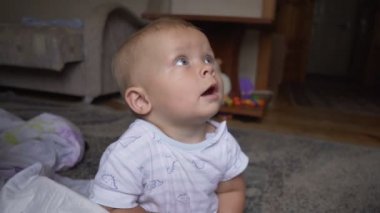 beyaz bir T-shirt bebek bezi içinde küçük bir çocuk tarar