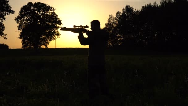 Людина на фоні заходу сонця з пістолетом Повільний рух — стокове відео