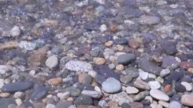 Dalgalar çakıl plaj üzerinde rulo