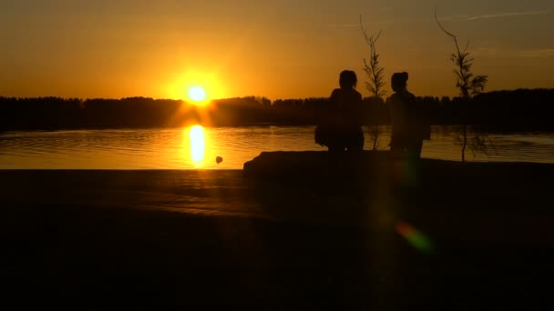 Mädchen laufen gegen den Sonnenuntergang am Strand entlang — Stockvideo