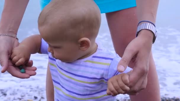 Mãe com uma criança pequena caminha ao longo da praia 4k — Vídeo de Stock