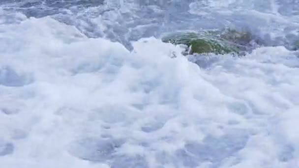 Agua salpicando en la costa rocosa cuando salpica lentamente — Vídeo de stock