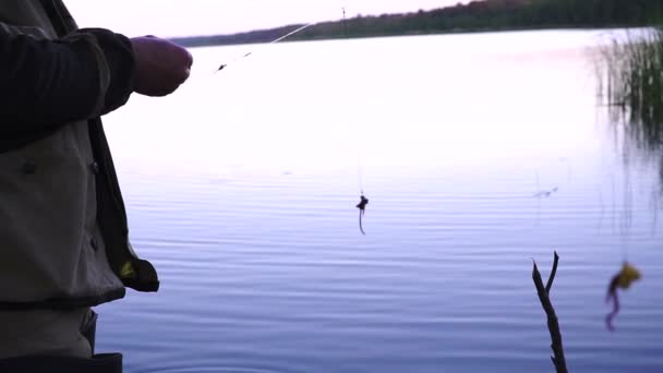 Pescatore mette vermi come esca per il pesce sulla canna del gancio — Video Stock