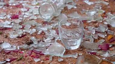 bir bardak votka kırık cam arka plan üzerinde. düşmüş bir şişe