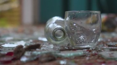 bir bardak votka kırık cam arka plan üzerinde. düşmüş bir şişe