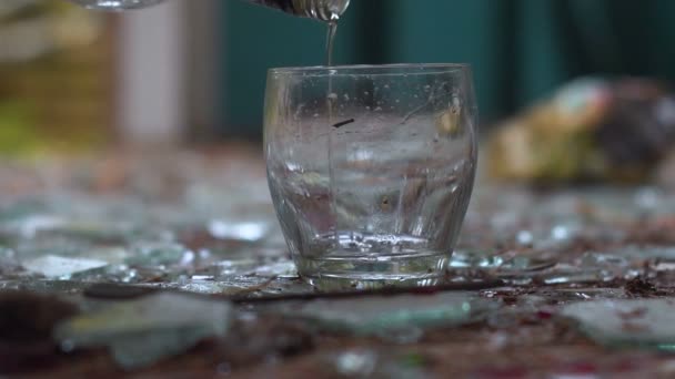 Kieliszek wódki na niesamowite tła tłuczonego szkła. kradzież — Wideo stockowe