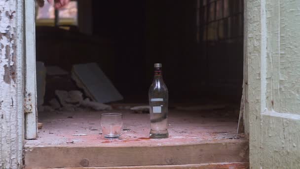 A garrafa de vodka e vidro no edifício arruinado — Vídeo de Stock
