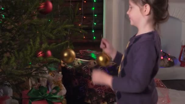 女の子はクリスマス ツリーを飾る — ストック動画