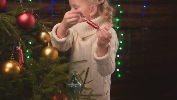 Menina veste-se uma árvore de Natal — Vídeo de Stock