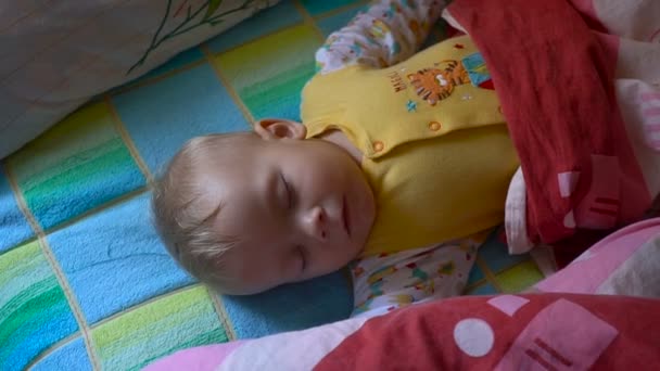 Portrait of a sleeping and waking up baby in bed — Stock Video