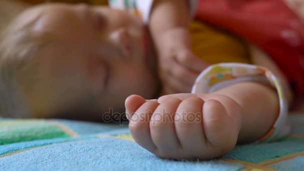 Retrato de un bebé durmiendo y despertando en la cama — Vídeo de stock