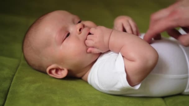 Счастливый новорожденный ребенок зевает крупным планом в белой постели — стоковое видео