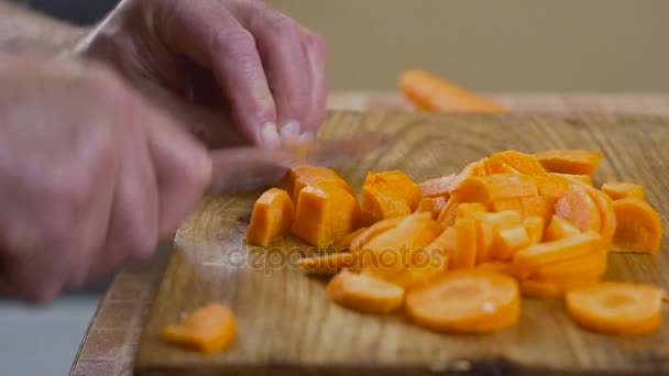 Las zanahorias picadas en la tabla de cortar a la mesa — Vídeos de Stock