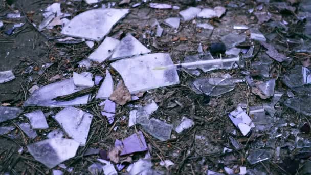 Jeringa cayendo rociando sangre después de una inyección de cocaína de heroína en cristales rotos . — Vídeo de stock