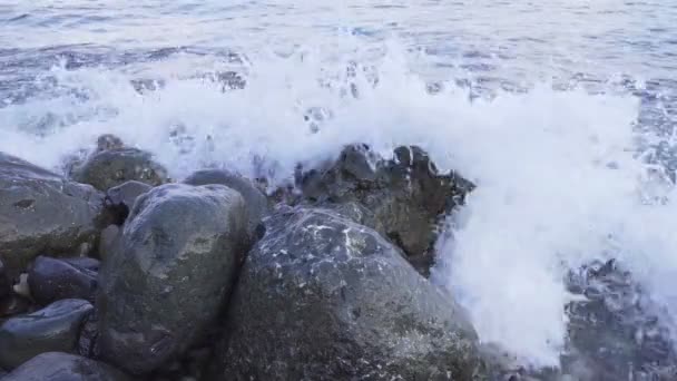 Вода бризкає на кам'янистому березі, а вітерець бризкає повільний рух — стокове відео