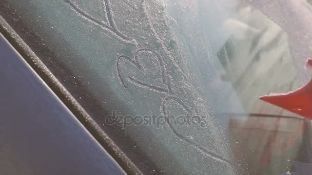 Love symbol heart on frozen snowy car window glass — Stock Video