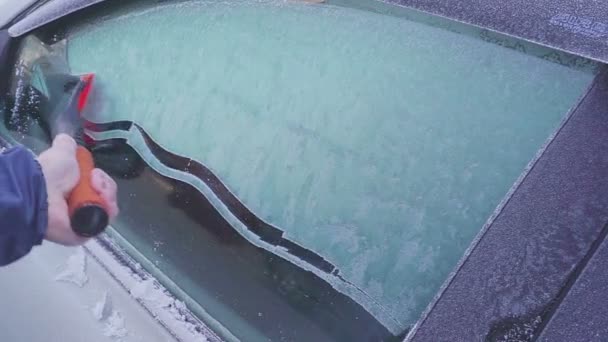 Скребание льда и снега из машины — стоковое видео