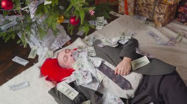 Bir adam bir sürü dolar ve bir Noel ağacı ile uyuyor