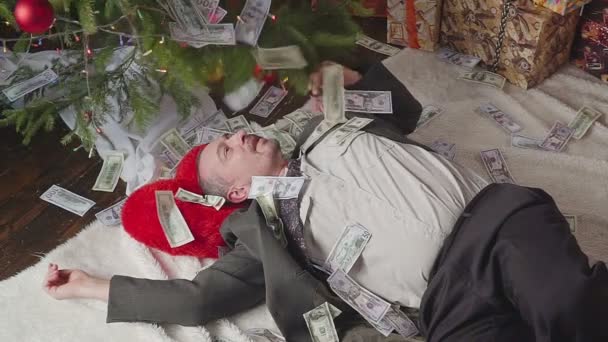 Un homme dort avec beaucoup de dollars et un sapin de Noël — Video