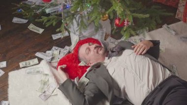 Bir adam bir sürü dolar ve bir Noel ağacı ile uyuyor