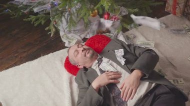 Noel ağacının yanında uyuyan bir adam para düşüyor