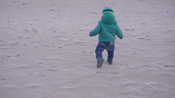 Щаслива дитина грає на березі моря — стокове відео