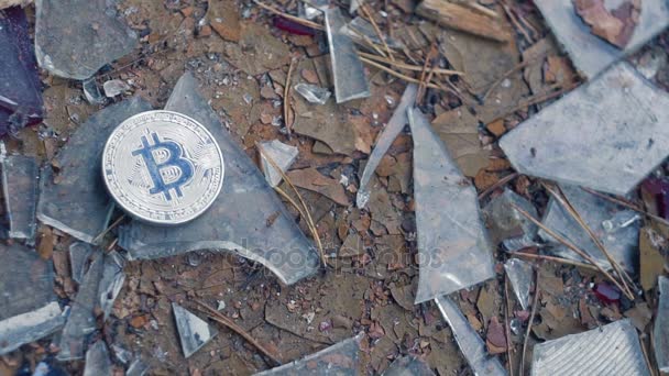 Silver bitcoin falls on broken glass — Stock Video