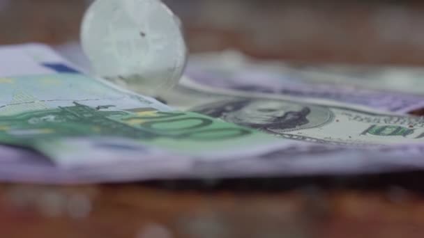 Stříbrný bitcoin roll a otočit na pozadí peníze. Dolar, euro — Stock video