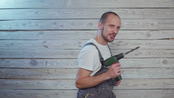 Obrero de la construcción con un taladro en la mano bailando divertido — Vídeos de Stock