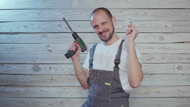 Dançando trabalhador da construção civil com dinheiro e broca em sua mão — Vídeo de Stock