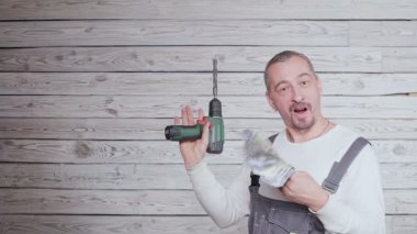 İnşaat işçisi para ile dans ve elinde matkap