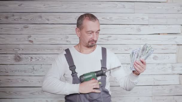 Танцующий строитель с деньгами и дрелью в руке — стоковое видео