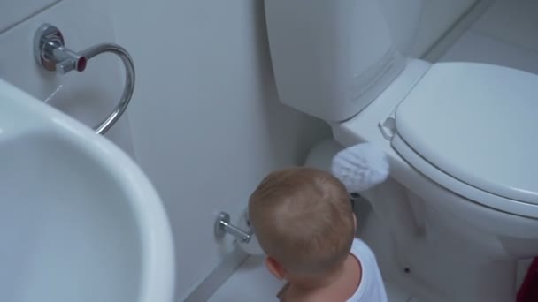 Baby boy with toilet cleaning brush — Stock Video