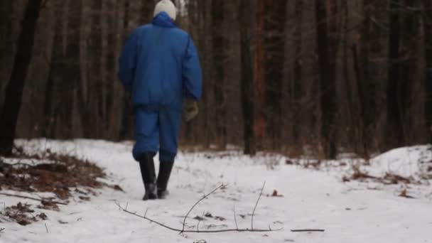 En man som går på en skog spår i snö — Stockvideo