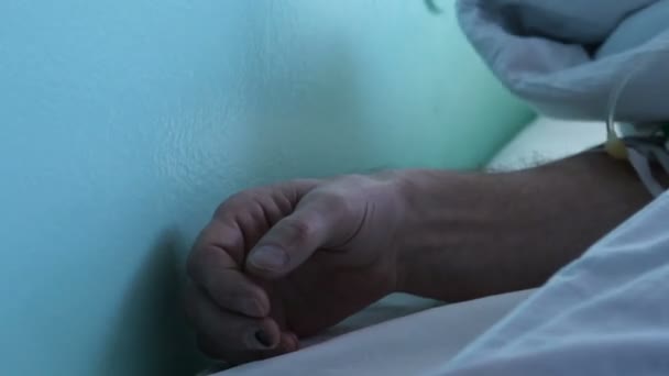 Рука мужчины после операции лежит в больнице — стоковое видео