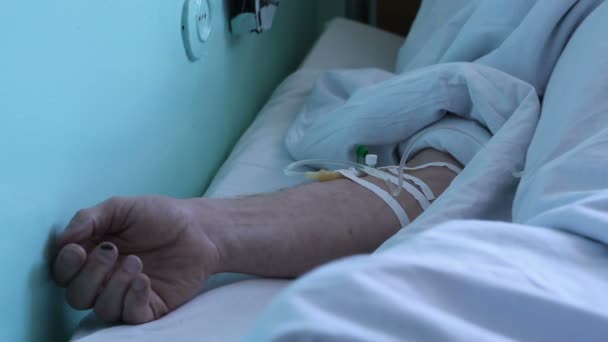 Die Hand des Mannes liegt nach der Operation im Krankenhaus — Stockvideo