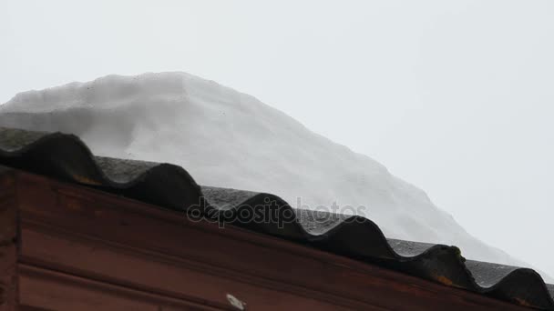 Frühlingsschnee schmilzt auf dem Dach altes Haus. — Stockvideo