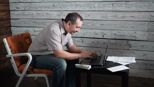 Vijftig jaar oude gek man online-account controleert en viert winnen op zijn laptopcomputer — Stockvideo