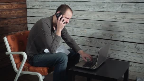 Caucásico joven freelancer habla por teléfono y habla sobre el éxito — Vídeo de stock