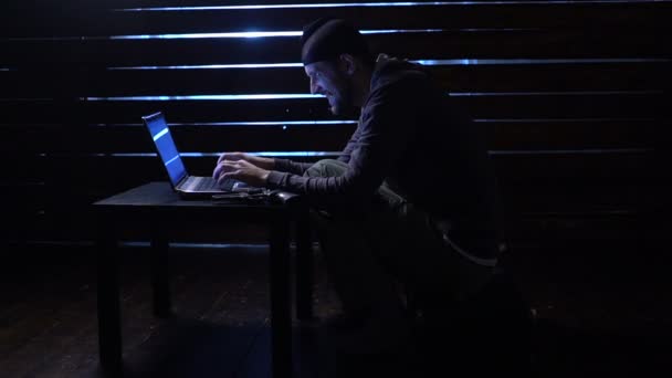Comic funny hacker commits a cyber attack with a laptop and a gun in his hands — Stock Video