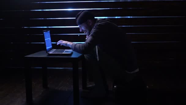 Comic funny hacker commits a cyber attack with a laptop and a gun in his hands — Stock Video