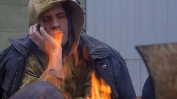 Triste sin hogar por el fuego primer plano — Vídeo de stock