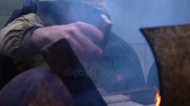 Evsiz adam ellerini ateşin yanında Isınma