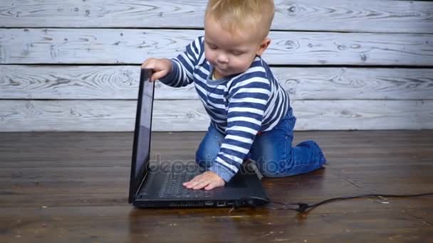 Beautiful one year old child is played with a laptop. business comcept — Stock Video